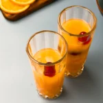 Sex on the beach drink recept - en fruktig cocktail med apelsin, persikosnaps och och vodka - lite tranbärsjuice körsbär och apelsinskiva sen är den redo att drickas