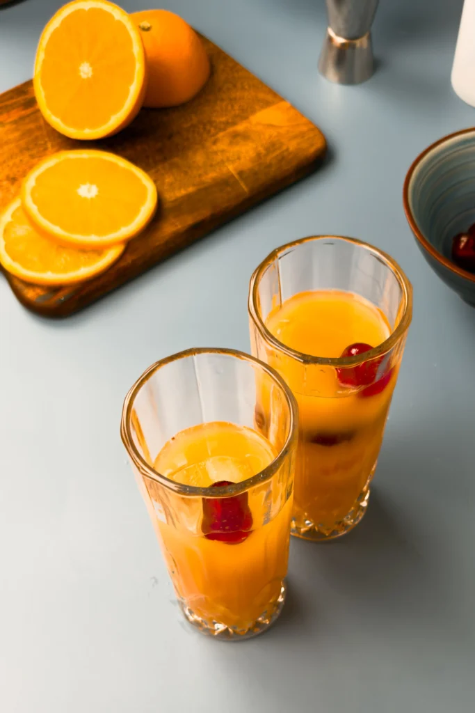 Sex on the beach drink recept - en klassisk cocktail gjord på vodka, persikosnaps, apelsinjuice, tranbärsjuice och garnerad med apelsin och körsbär