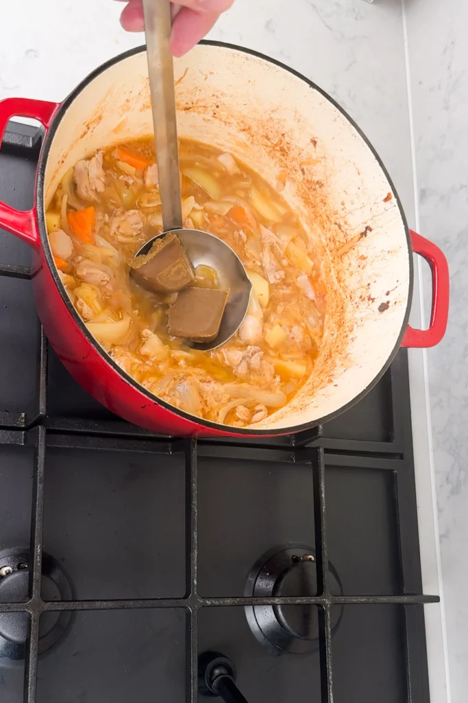 TIllsätt curry roux i en soppslev och vispa med ett par pinnar för att lösa upp curryn i buljongen