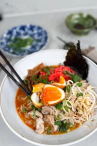 Snabb och enkel kyckling-ramen recept - en ramen-soppa med nudlar sedd uppifrån toppad med ägg och etc.