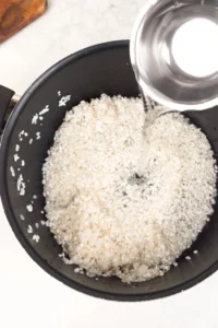 Mät upp ris och vatten. Använd 2 dl japanskt ris per portion, och tilsätt 2,2-2,4 dl vatten