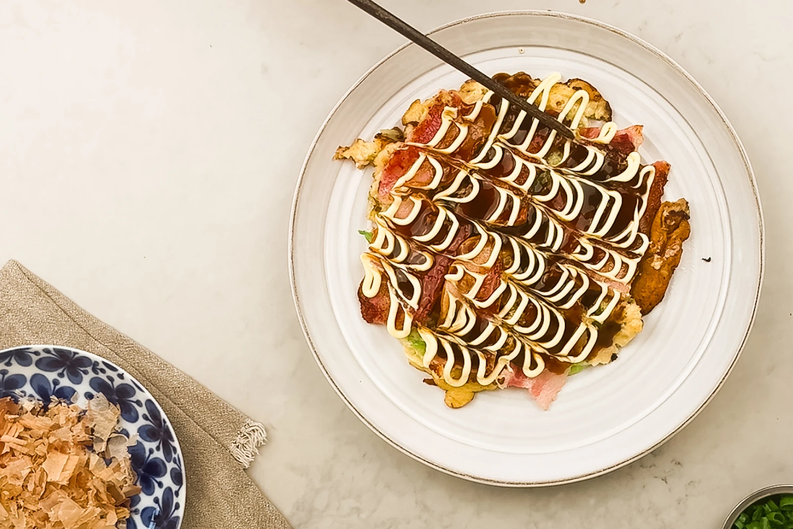 Okonomiyaki - en äkta japansk kålpannkaka serverad med sidfläsk, bonito och japansk majonnäs