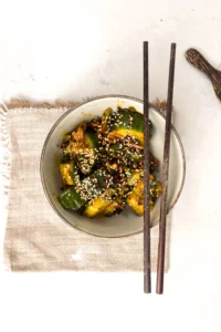 Toppa din asiatiska gurksallad med sesamfrön och servera med ätpinnar