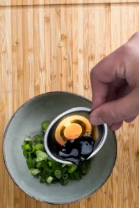 Blanda en asiatisk salladsdressing med soja, vinäger, sesamolja och laoganma chili crisp