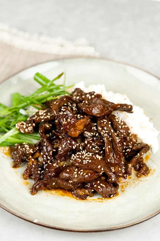 Närbild på biff Yakiniku, toppad med sesamfrön och salladslök