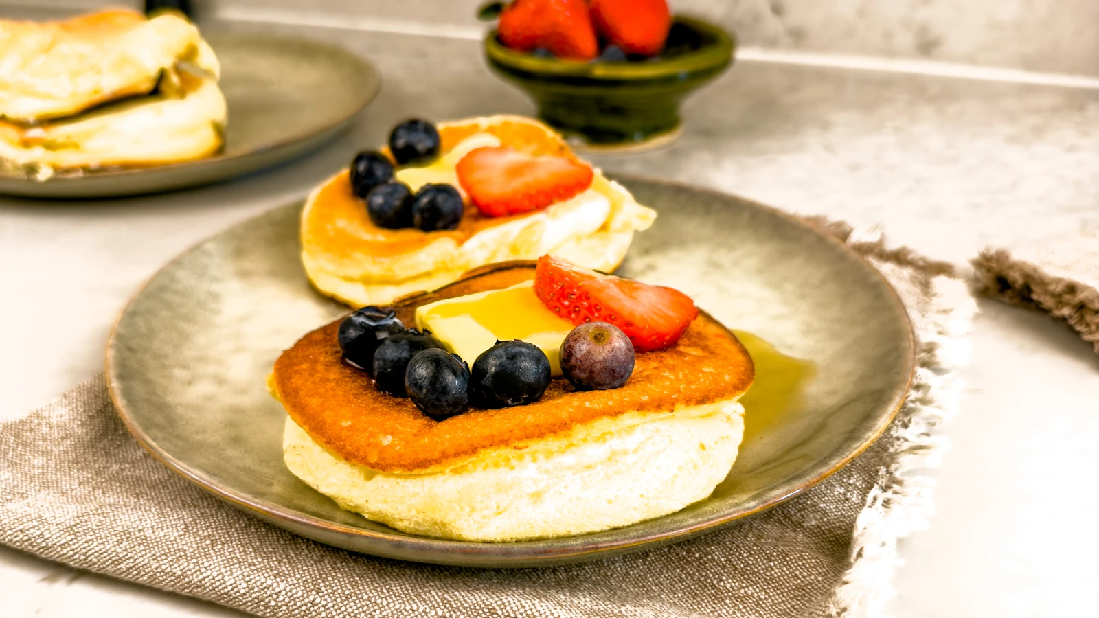 Recept på fluffiga japanska pannkakor serverade med färska bär (blåbär och jordgubbar), smör och lönnsirap - sufflepannkakor!