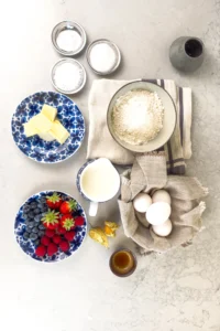 Amerikanska pannkakor ingredienser - mjölk, smält smör, vaniljextrakt, vetemjöl, bakpulver, salt och socker. Toppa med dina favoriter (smör, lönnsirap och färska bär)