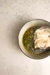Skopa upp soppa och dumplings över såsen