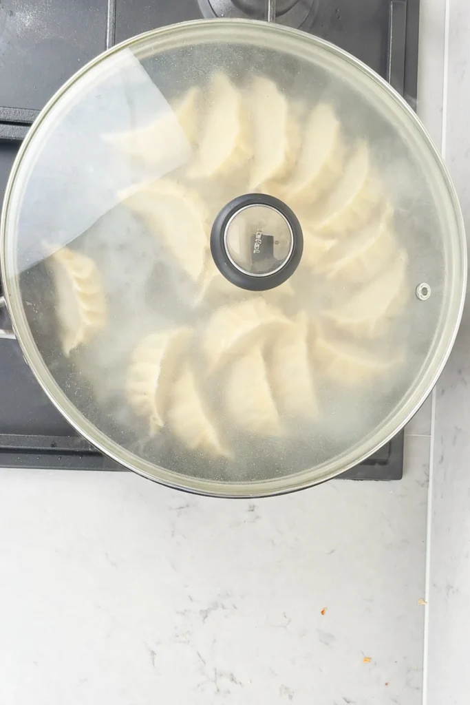 Tillsätt 5 msk vatten och ånga gyoza i 3 minuter med lock på